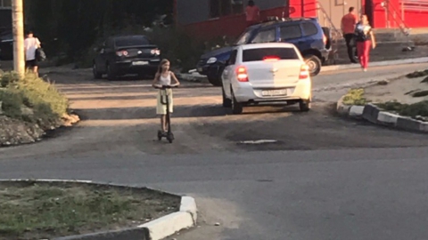 Девочка на самокате ездила по оживленной дороге